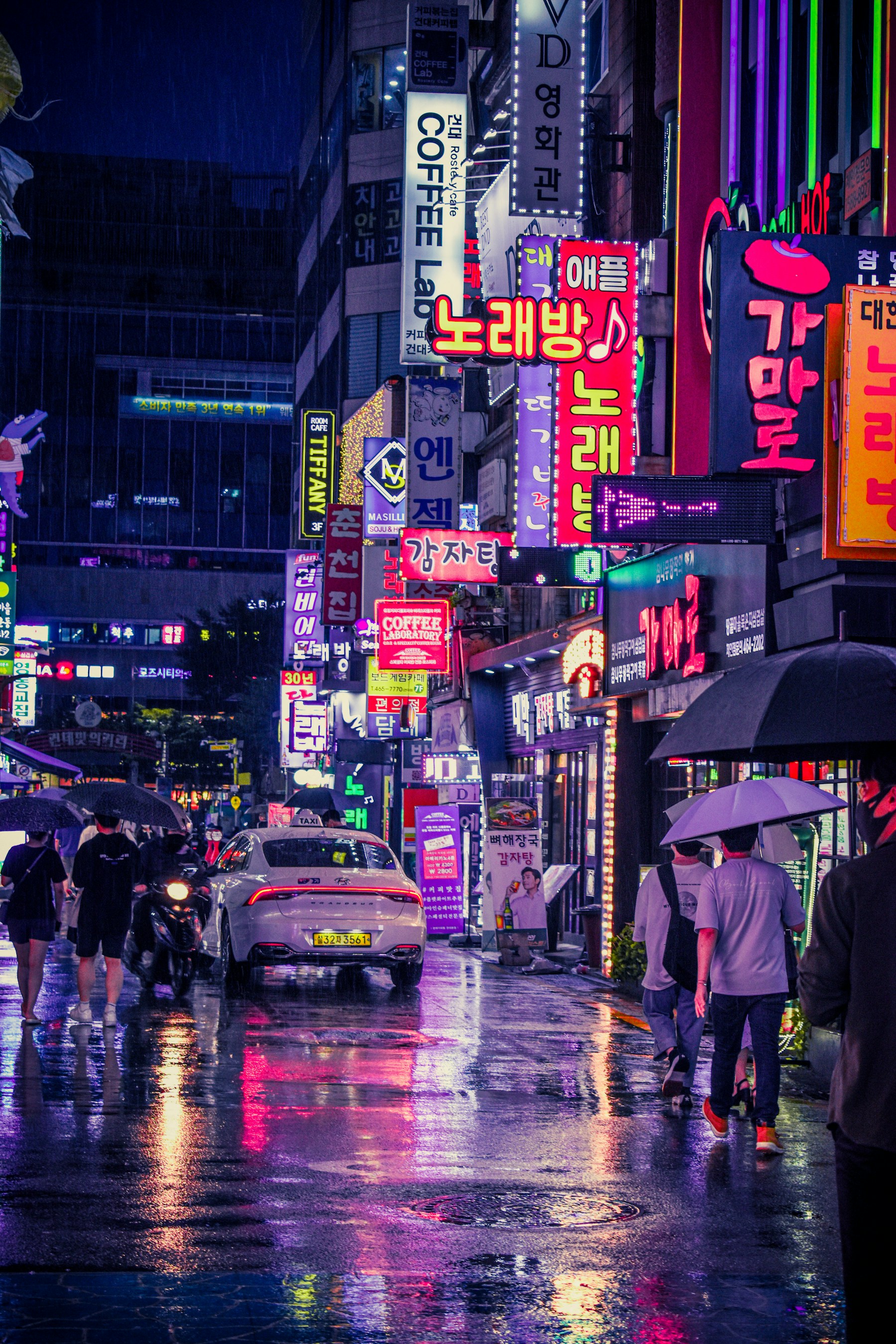 首尔雨夜里撑伞的行人和街道灯光